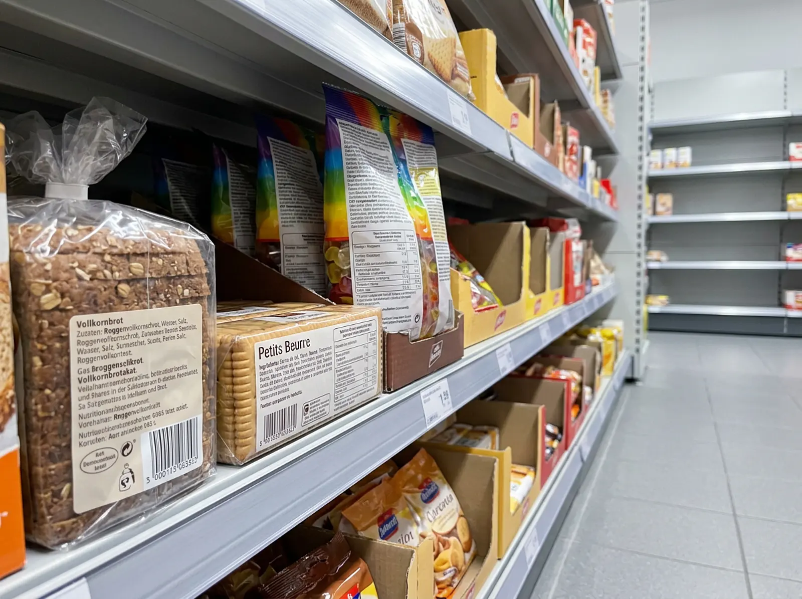 Low-angle view of a European grocery aisle with packaged baked goods and candy