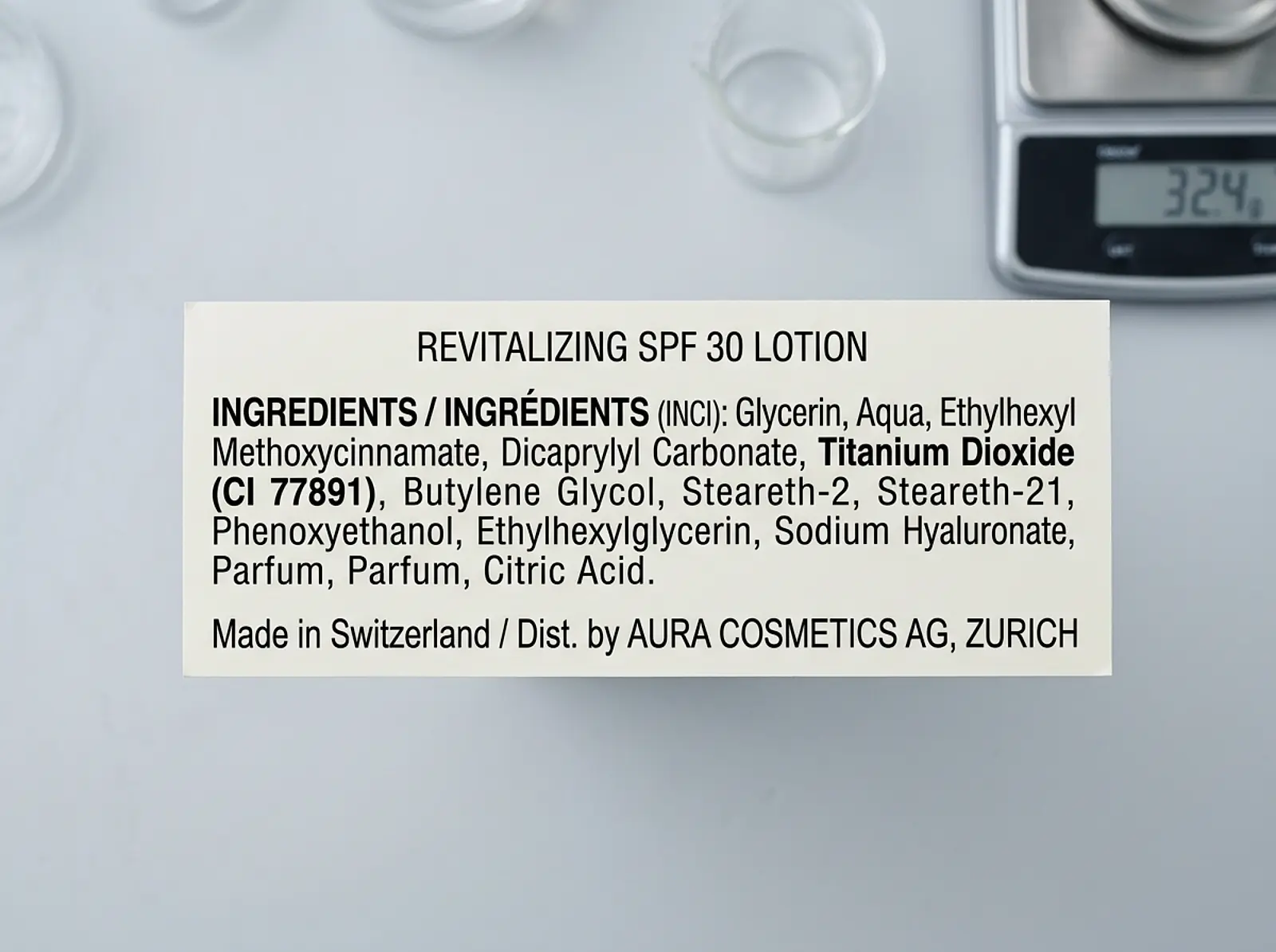Cosmetic label in studio macro photograph: INCI ingredient list showing 'Titanium Dioxide' against a neutral background