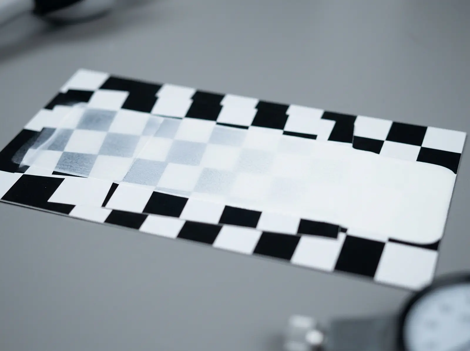 Macro studio close-up of a drawdown card with a white coating opacity gradient strip over substrate